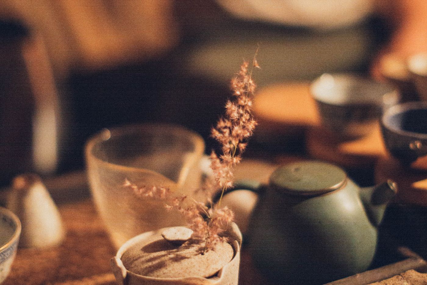 溫暖誘人的傳統茶具設置,燭光氛圍突出陶瓷茶杯和茶壺,呼應茶會活動的寧靜氛圍 | Warm and inviting traditional tea set setting, candlelight atmosphere highlighting ceramic teacups and teapot, echoing the tranquil ambiance of tea gatherings
