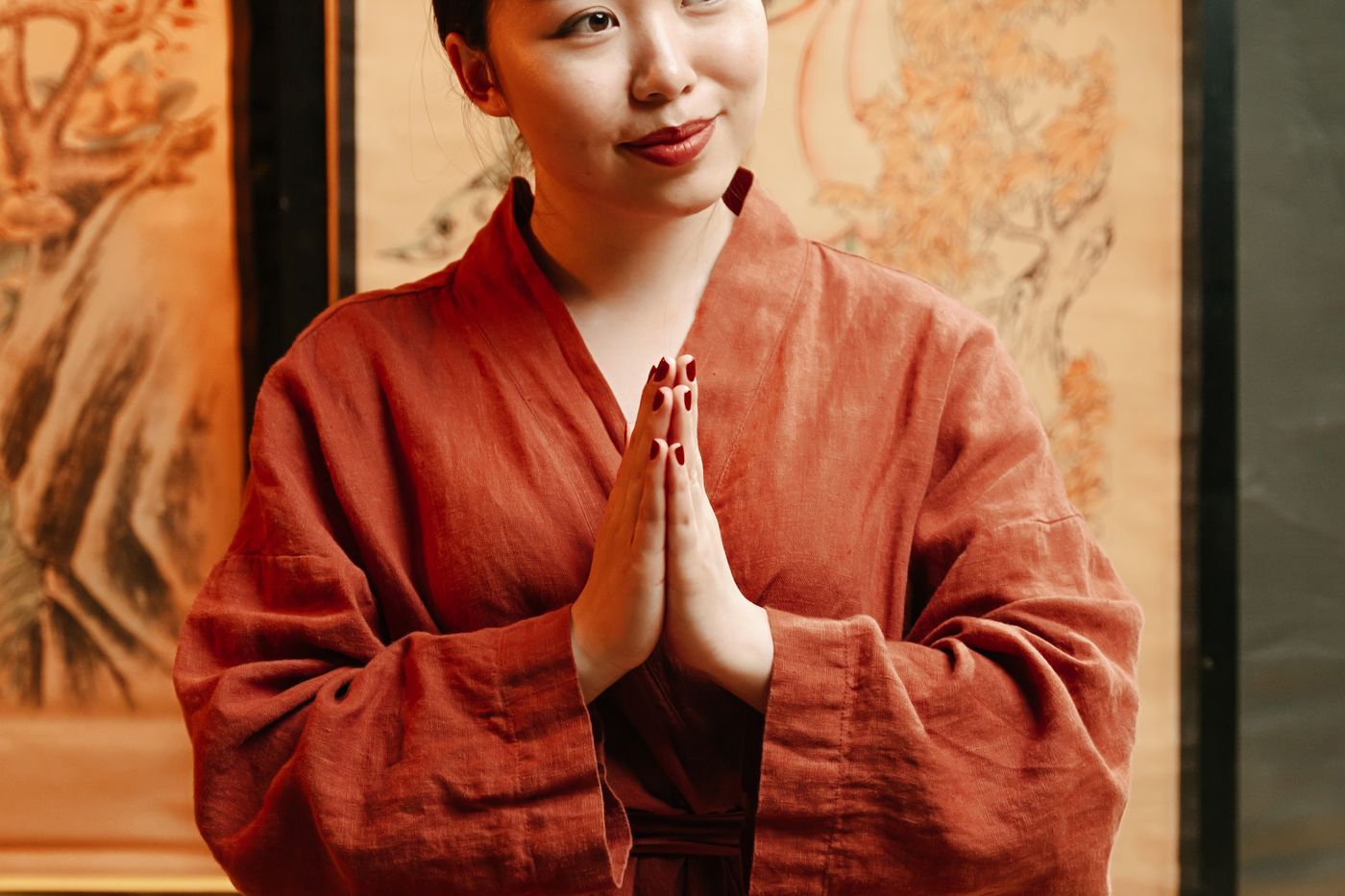 穿著紅色袍子的亞洲女性進行寧靜茶道儀式，呼應專業茶學課程的教學場景 | A woman in red robe performing a tranquil tea ceremony, echoing the teaching scene of professional tea courses