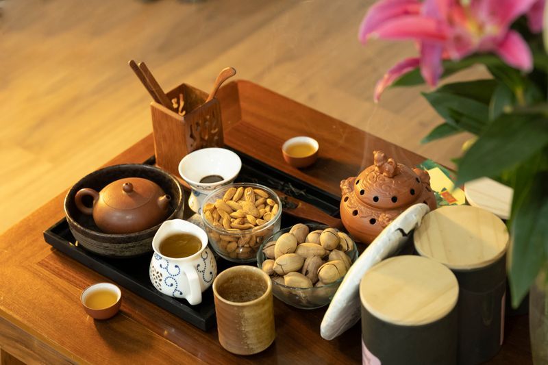 精美擺放的茶具與點心放在木制茶盤上,展現完整茶具組合 | Exquisitely arranged teaware and pastries on wooden tray showcasing complete tea set